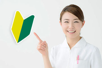 初めての方へ(若葉マークを指さす歯科スタッフ)